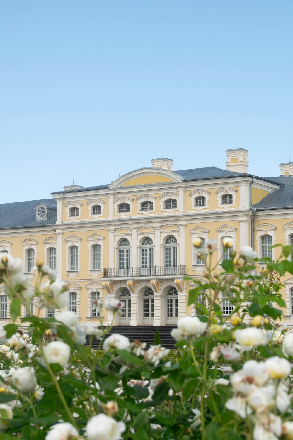 a large yellow building with white flowers in front of it