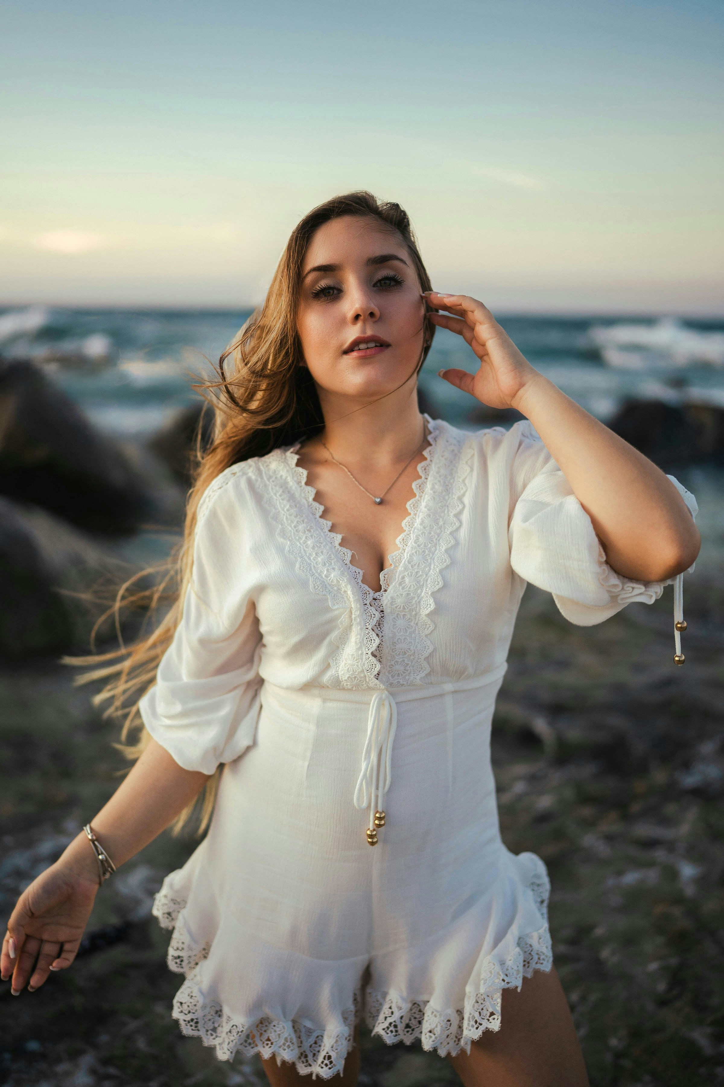 a woman in a white dress is posing for a picture