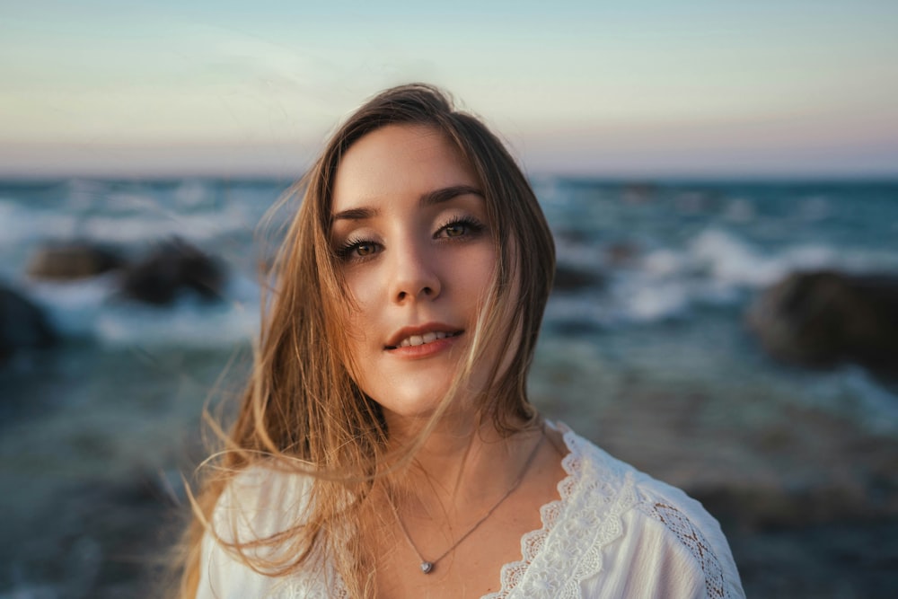 a woman standing in front of a body of water