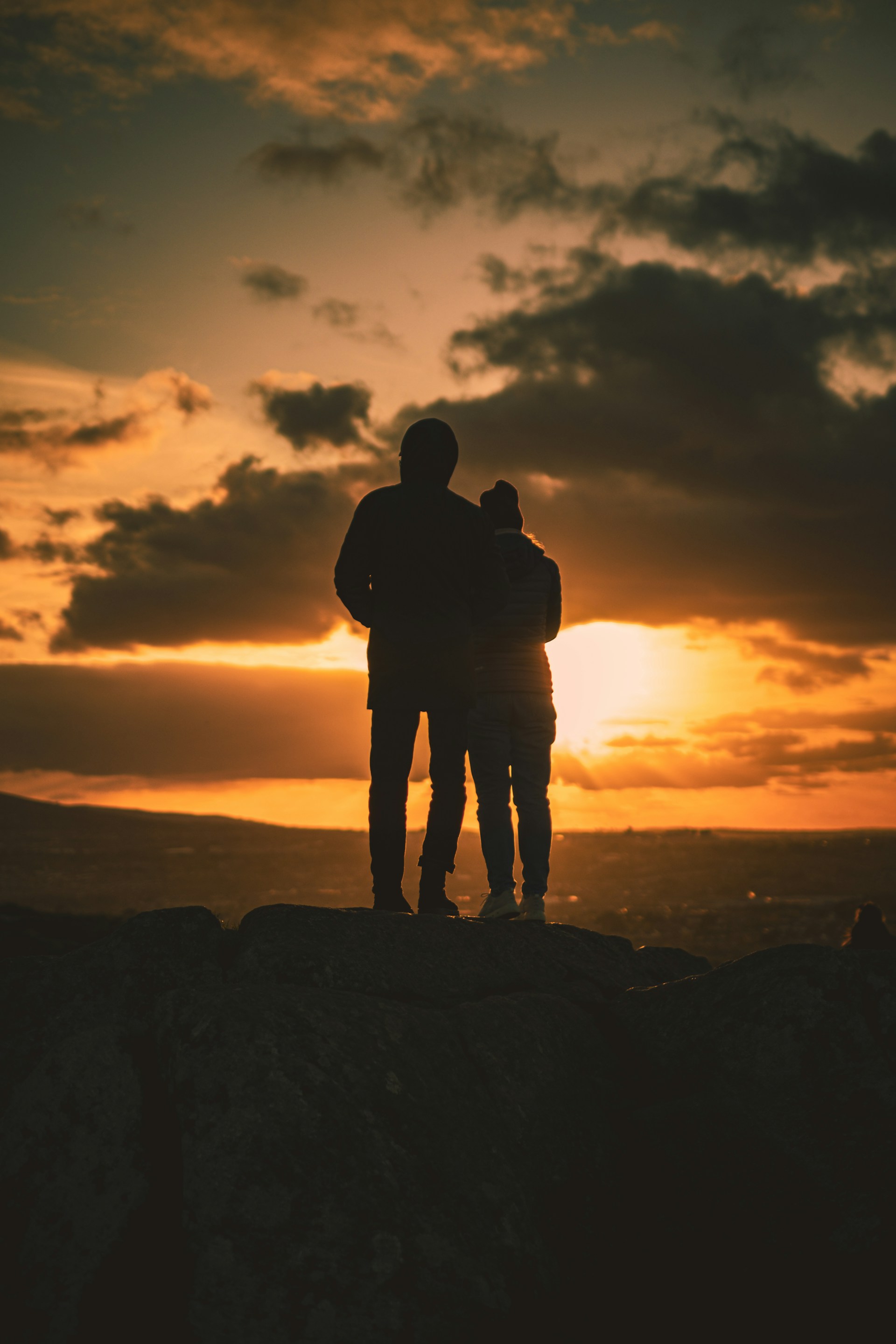a couple of people standing on top of a mountain