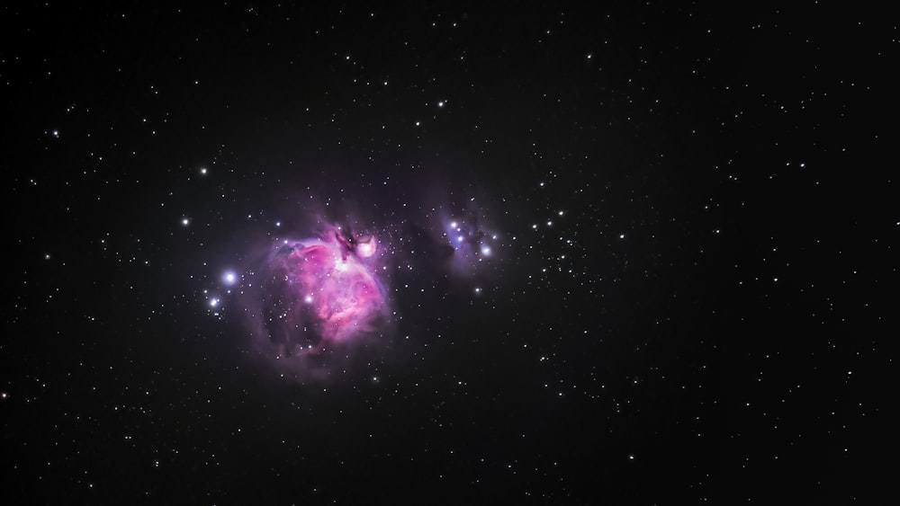 una estrella rosa y azul en medio de un cielo negro