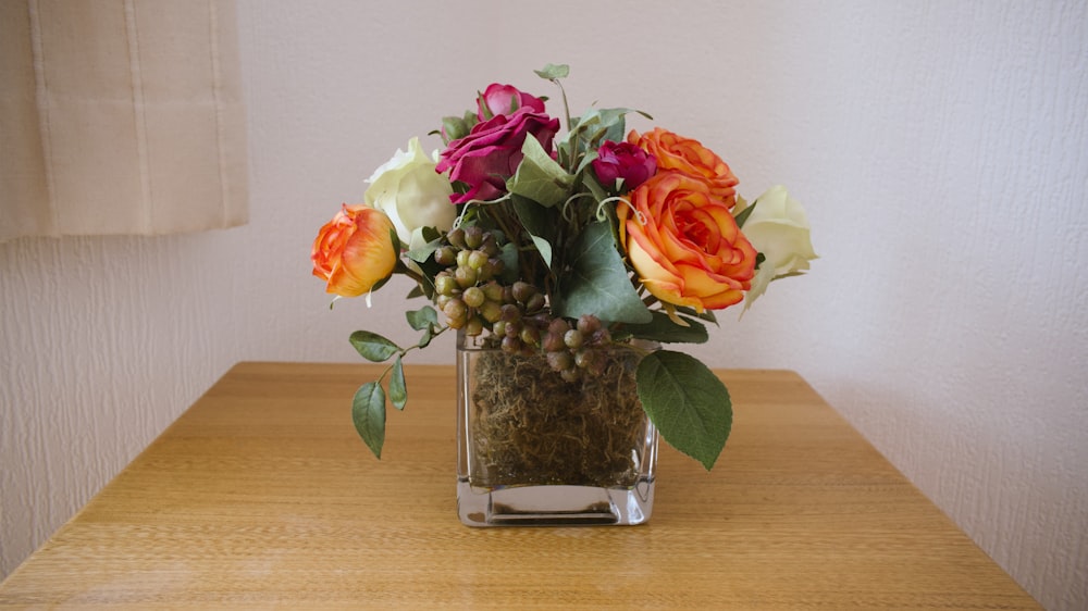 a vase filled with flowers on top of a wooden table