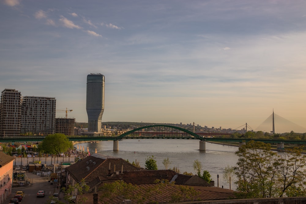 a bridge over a river with a city in the background