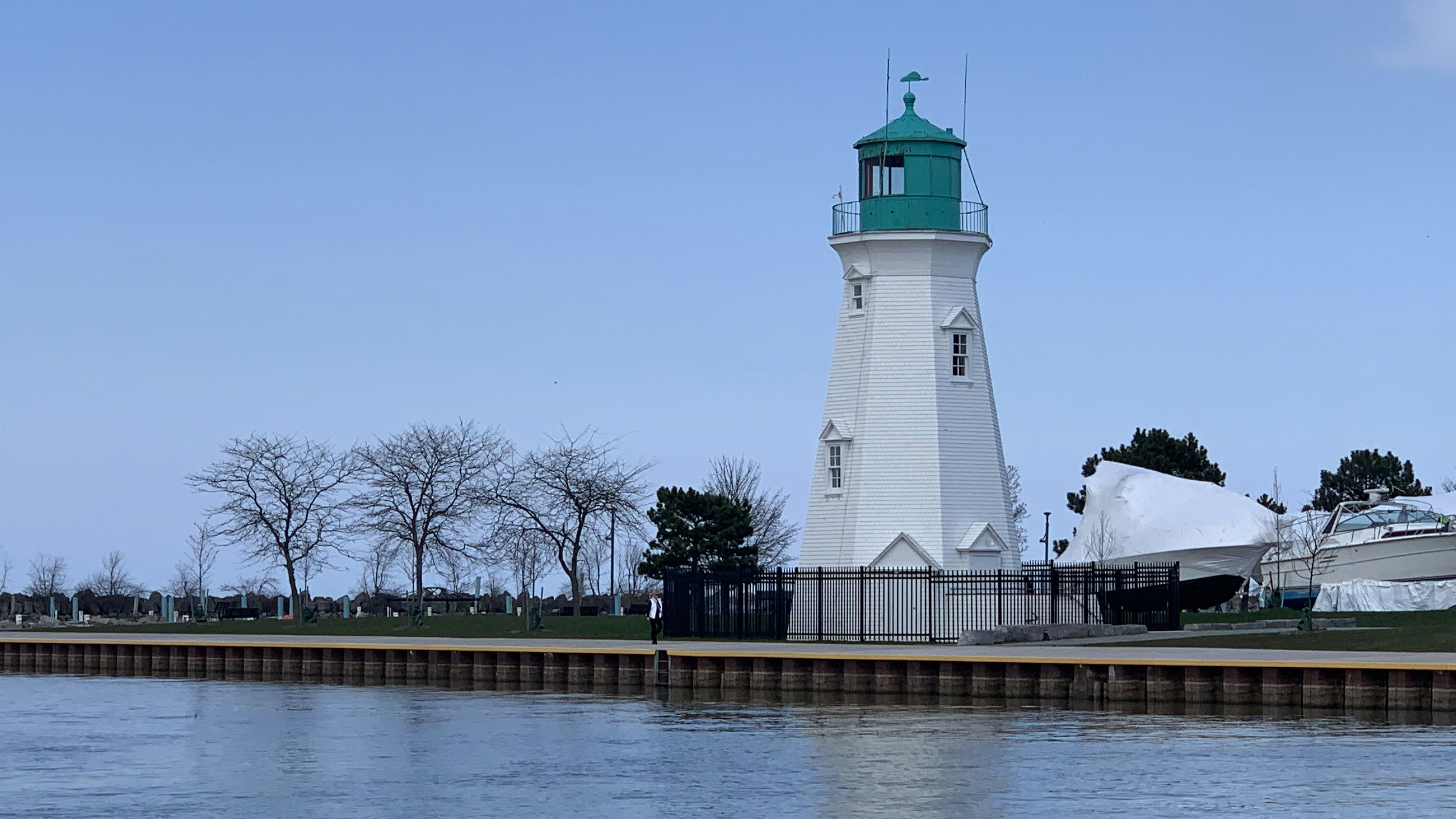 a light house sitting on the side of a body of water