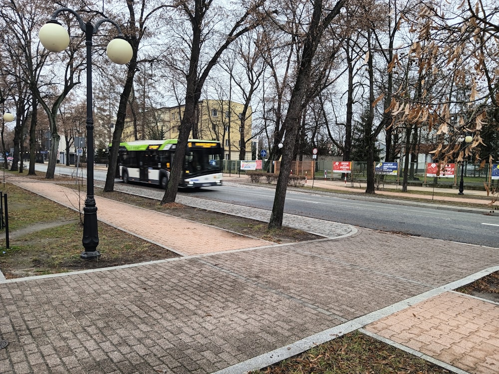 um ônibus dirigindo por uma rua ao lado de uma calçada