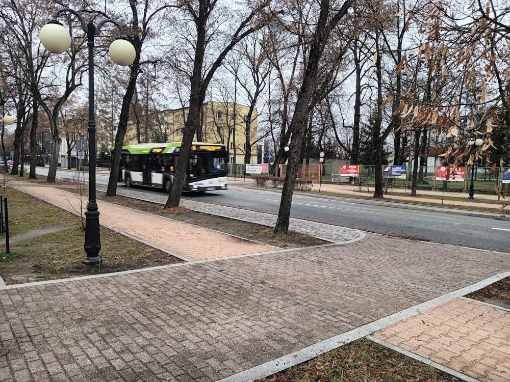 a bus driving down a street next to a sidewalk