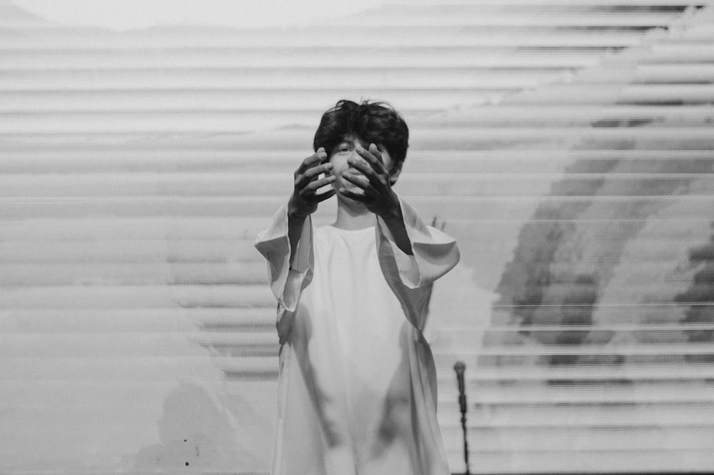 a black and white photo of a woman covering her face