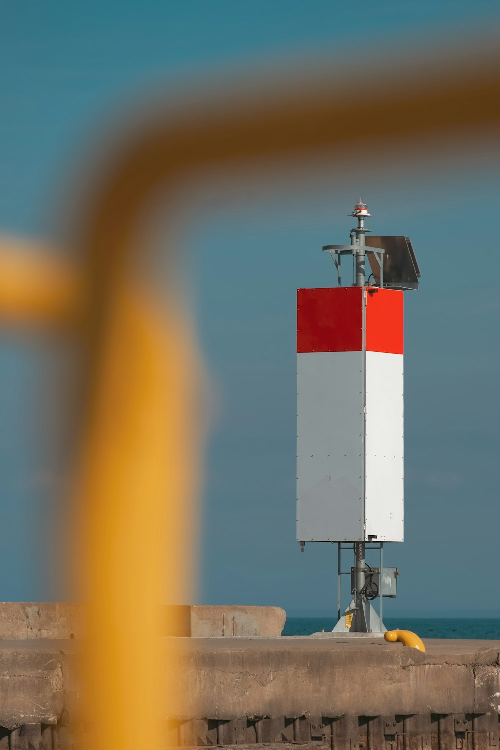 a red, white and blue tower sitting on top of a pier