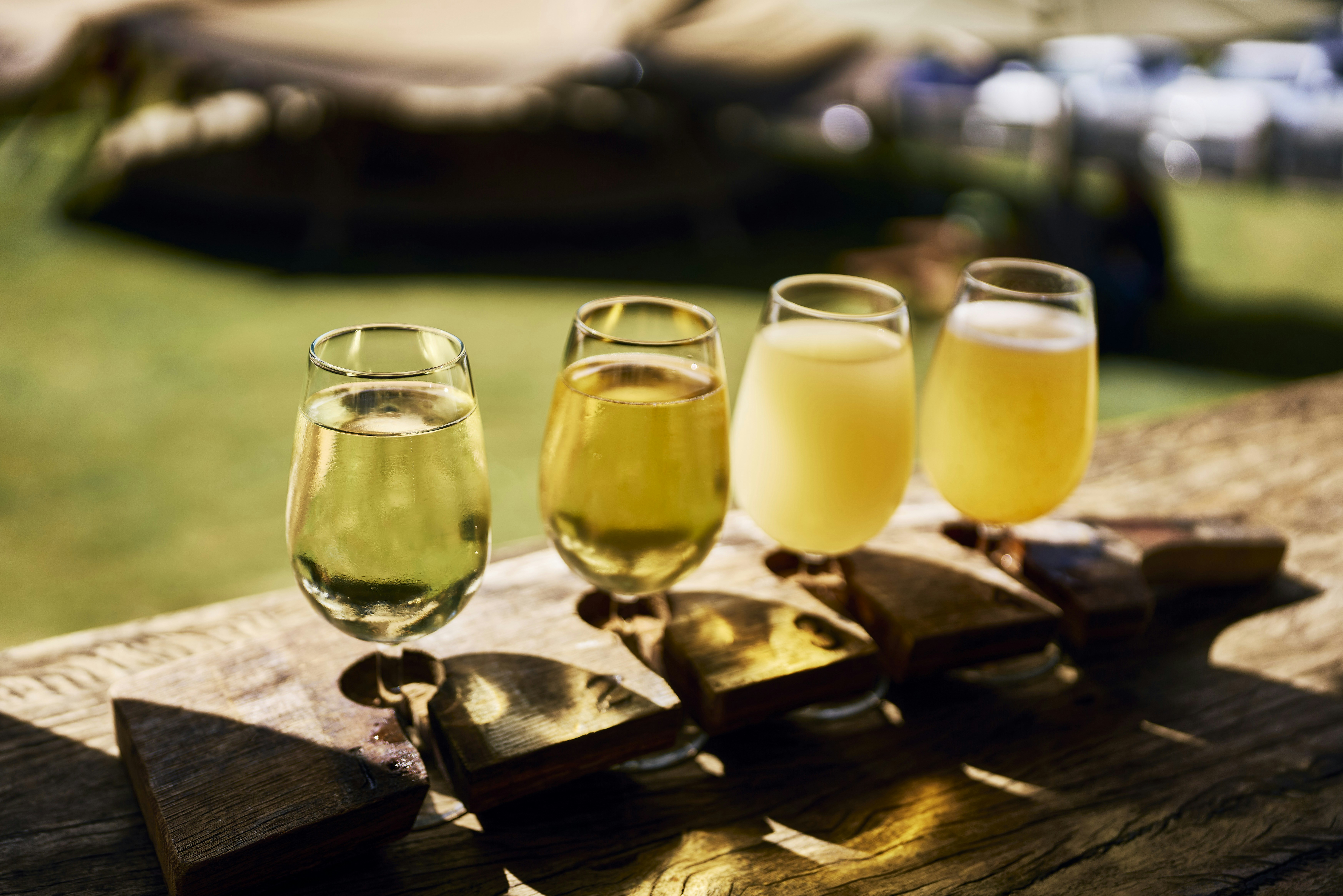 Tasting flight of pale beers on a wooden table outdoors