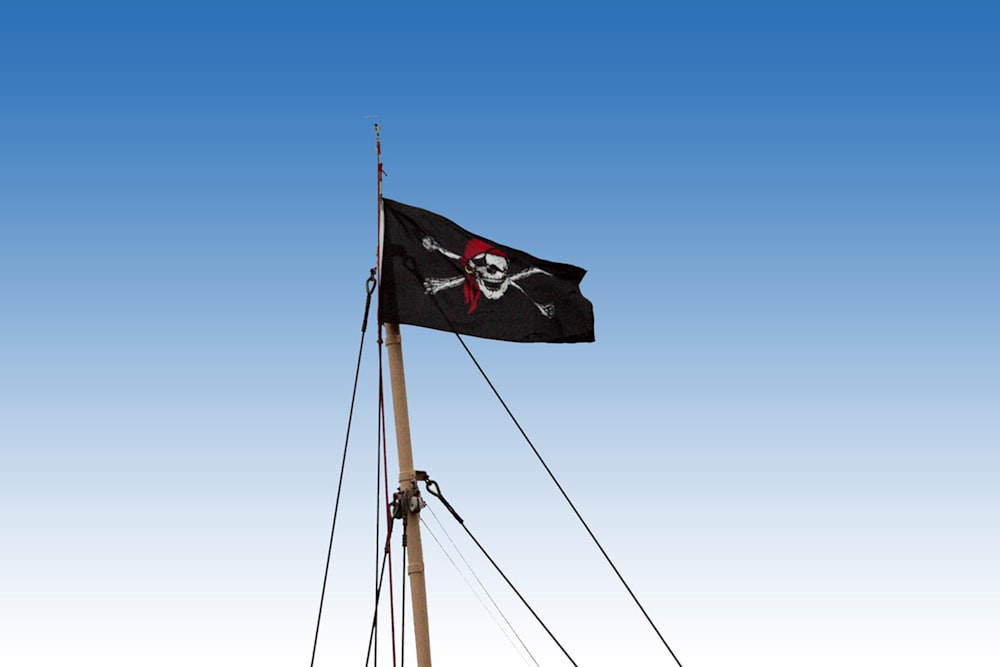 a pirate flag flying in the wind on a boat