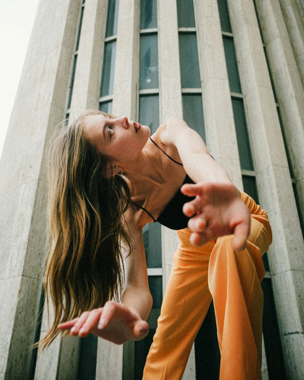 a woman is doing a handstand in front of a tall building