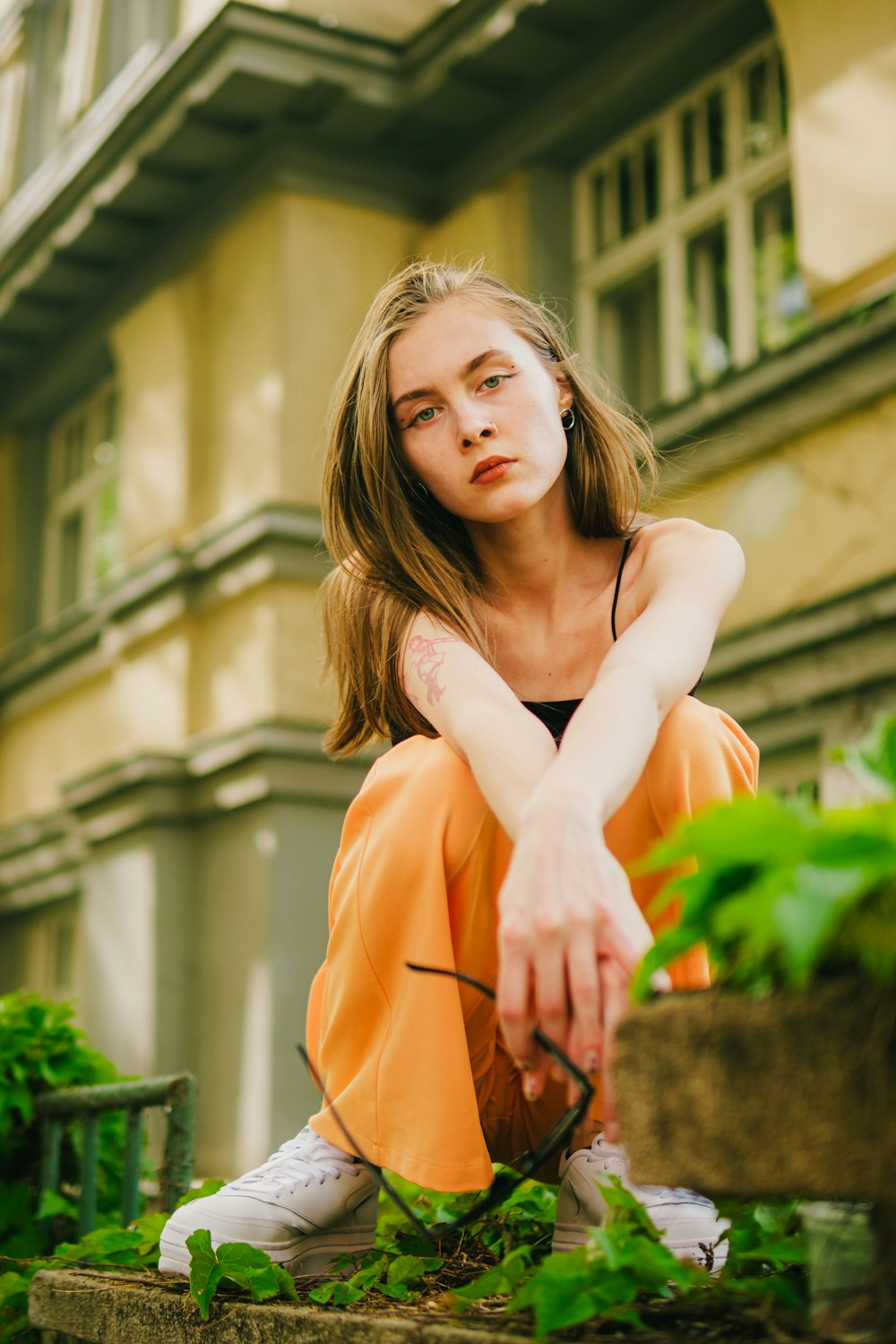 a woman sitting on the ground in front of a building