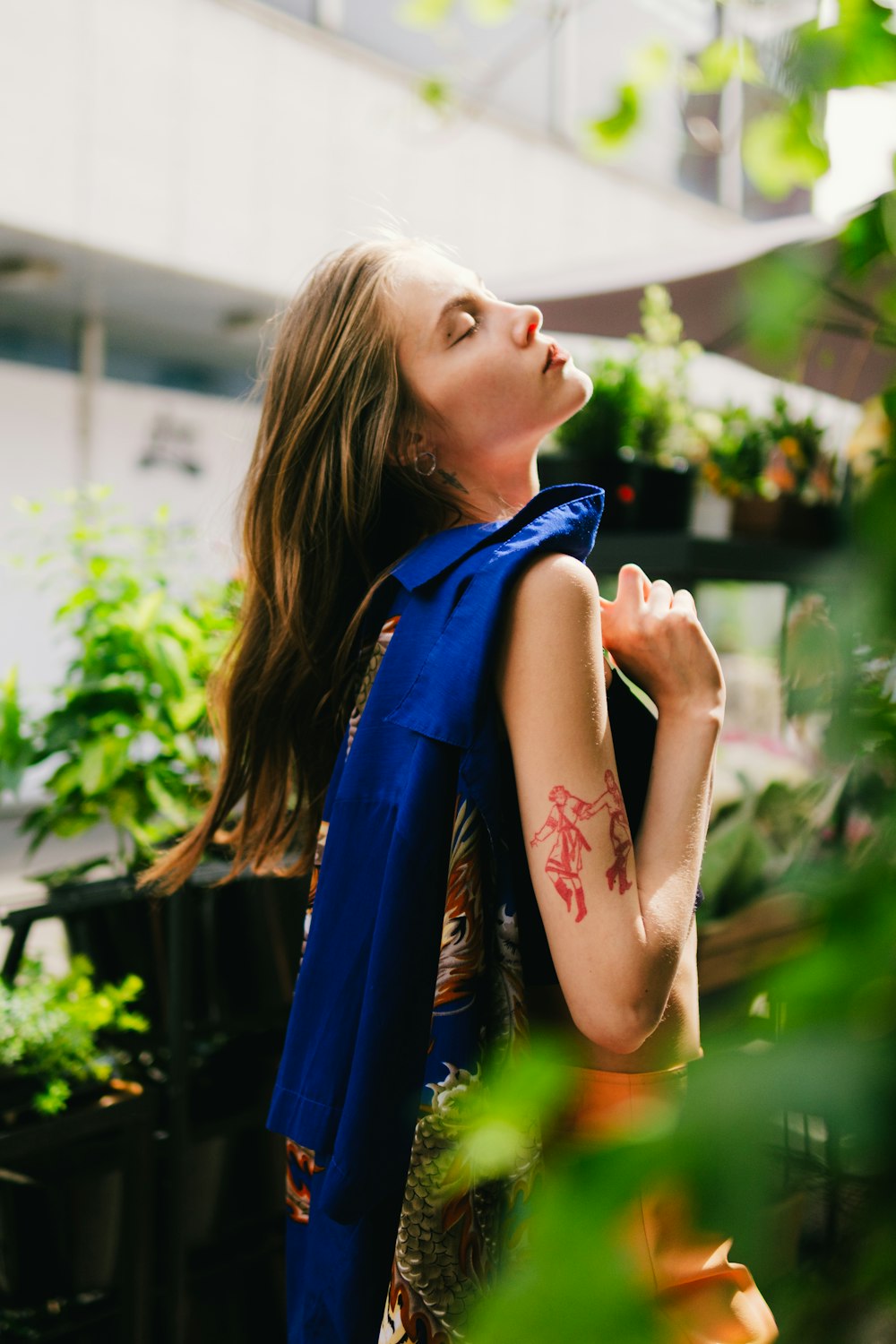 a woman standing in a greenhouse looking up