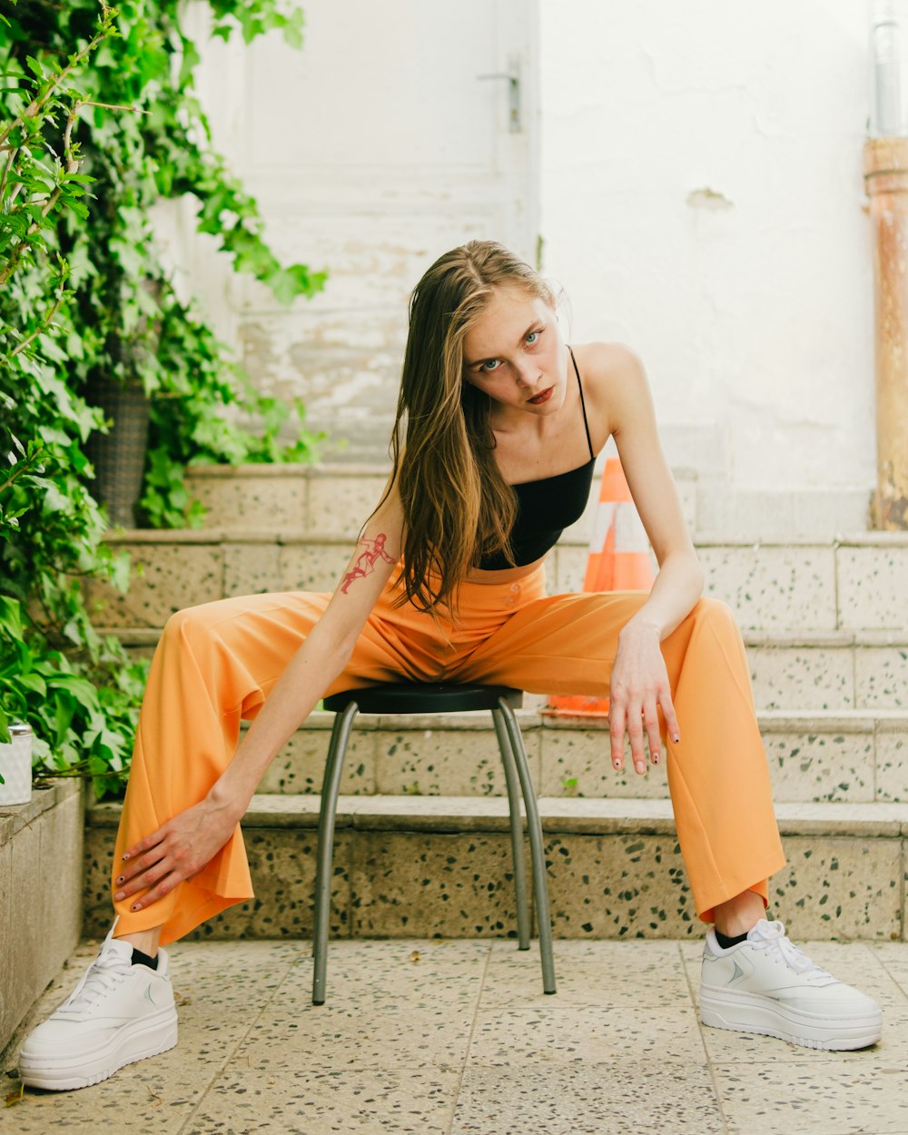 a woman sitting on a chair in an orange outfit