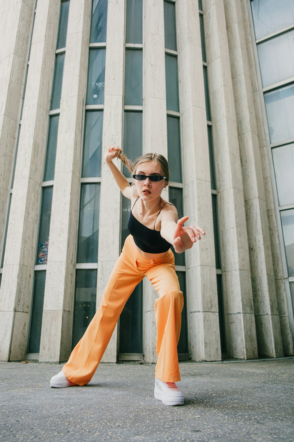 a woman in a black top and orange pants