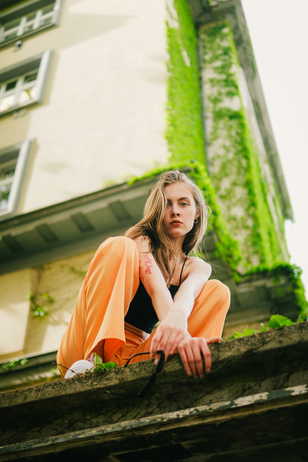 a woman sitting on a ledge in front of a building