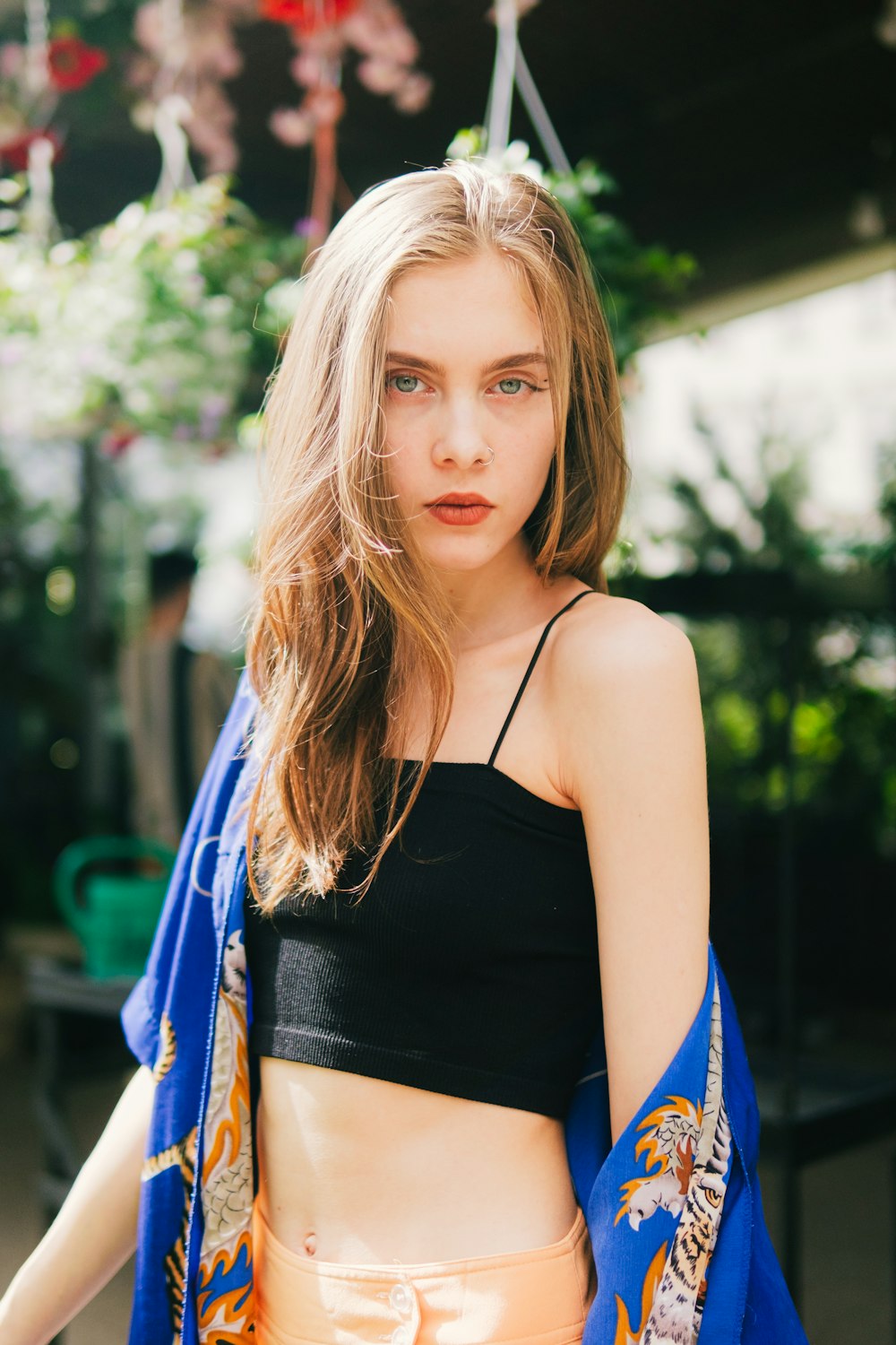 a woman in a black top and orange shorts