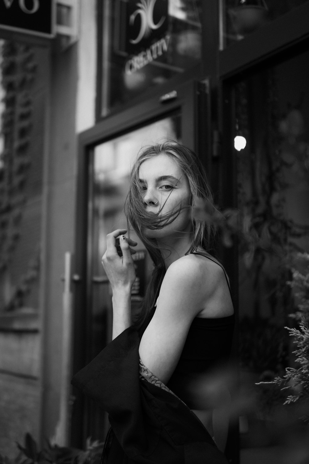 eine Frau in einem schwarzen Kleid raucht eine Zigarette