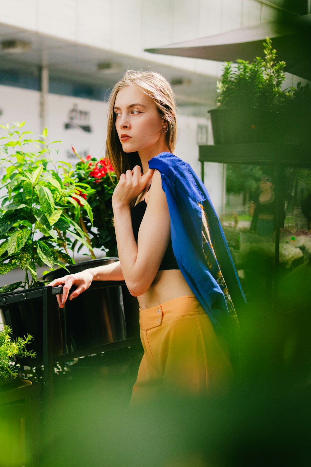 a woman standing in front of a potted plant