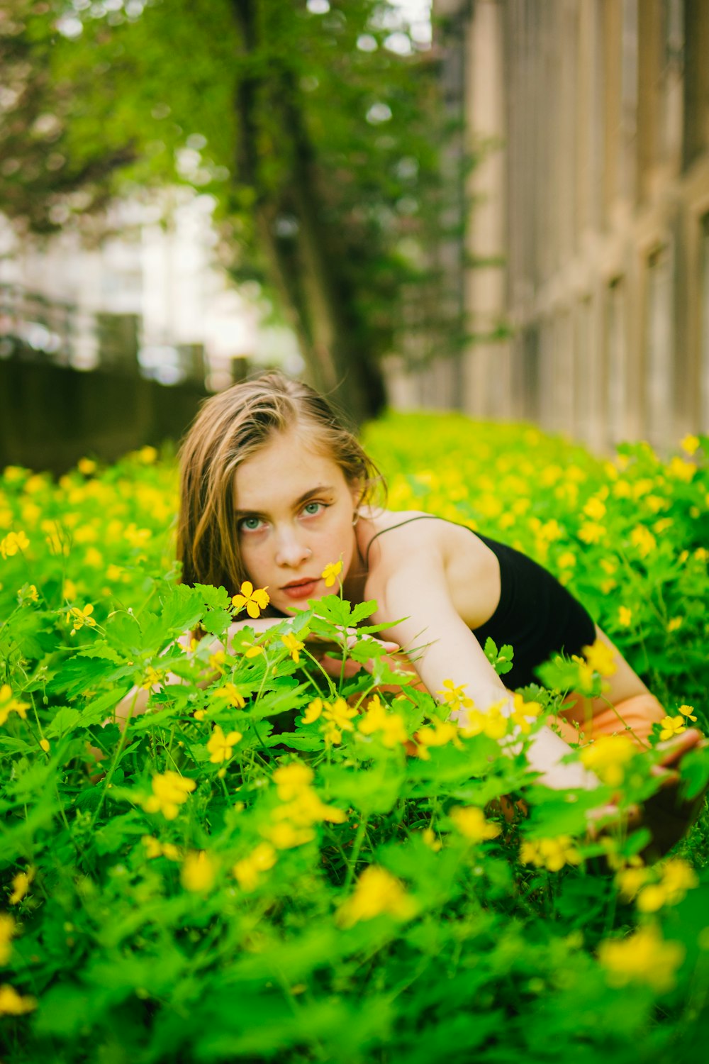 a woman laying in a field of yellow flowers