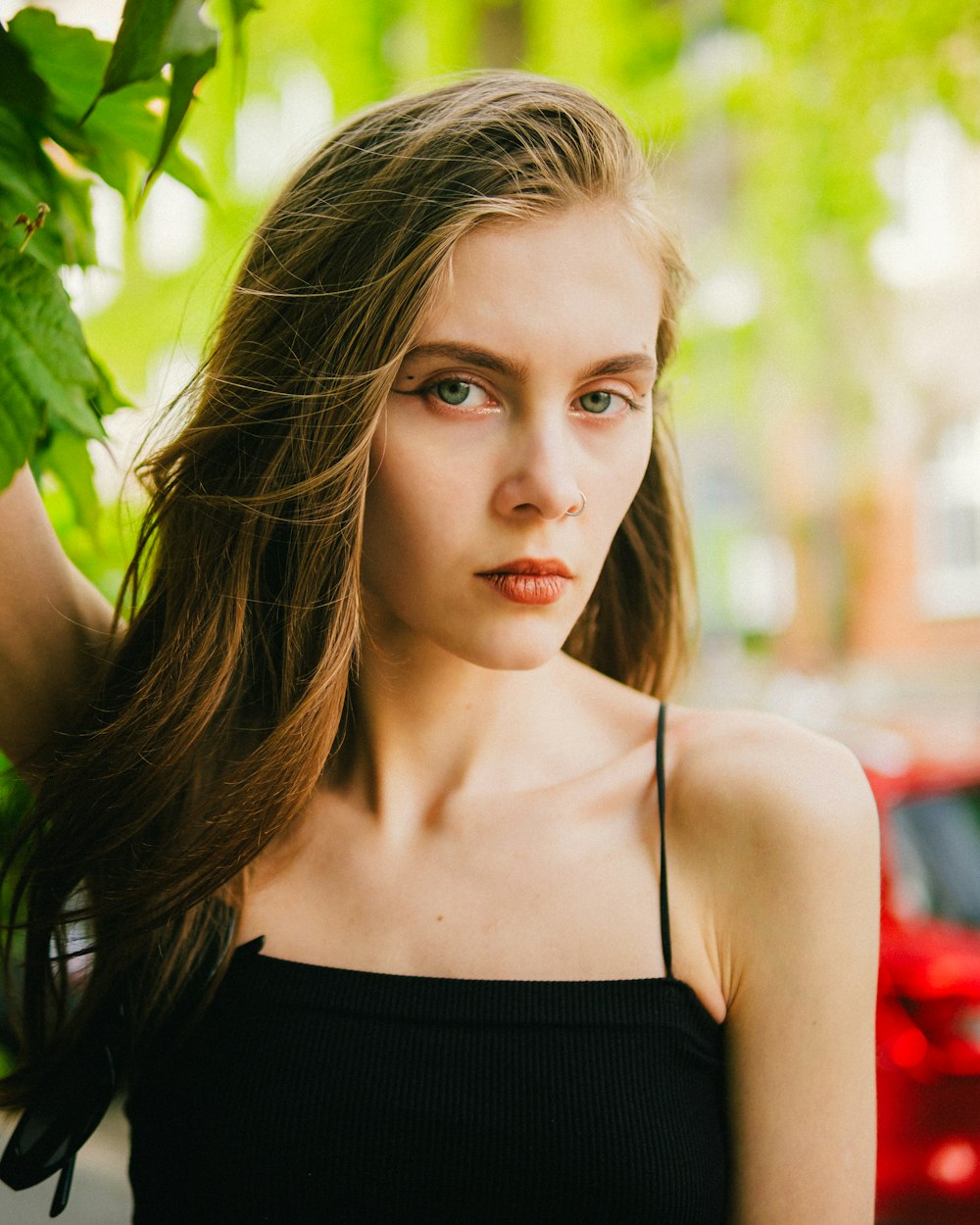 a woman with long hair standing next to a tree