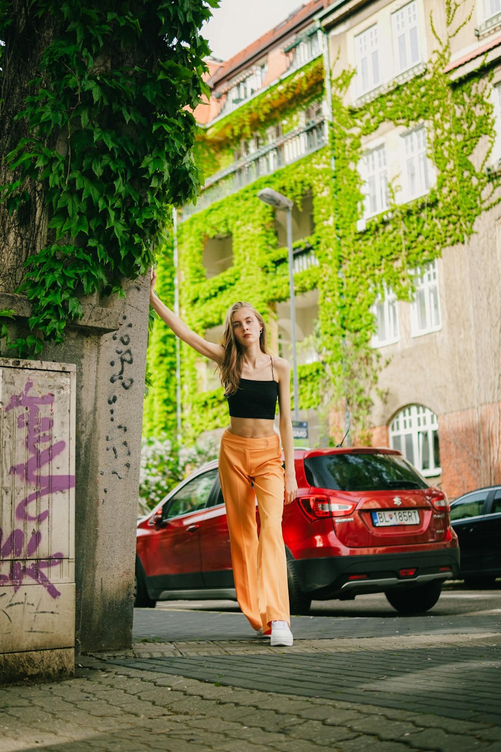 a woman in a black top and orange pants