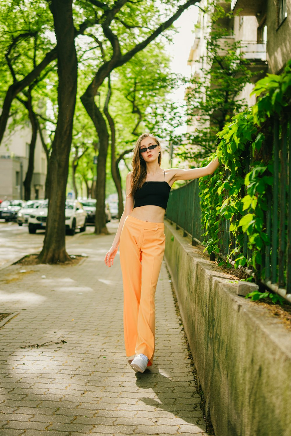 a woman in a black top and orange pants