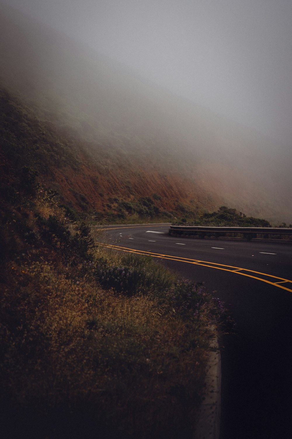 a foggy mountain road with a stop sign on the side