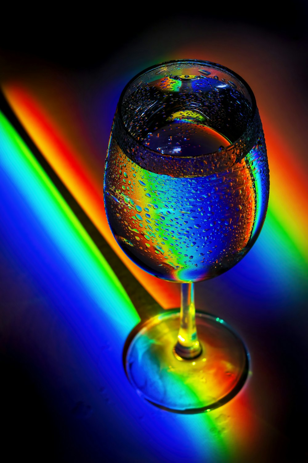 a wine glass with a rainbow in the background