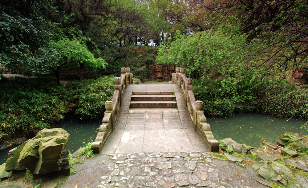 a stone bridge over a river surrounded by trees