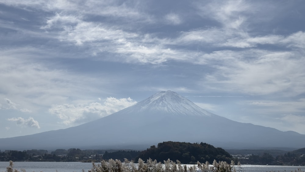 a snow covered mountain with a lake in the foreground