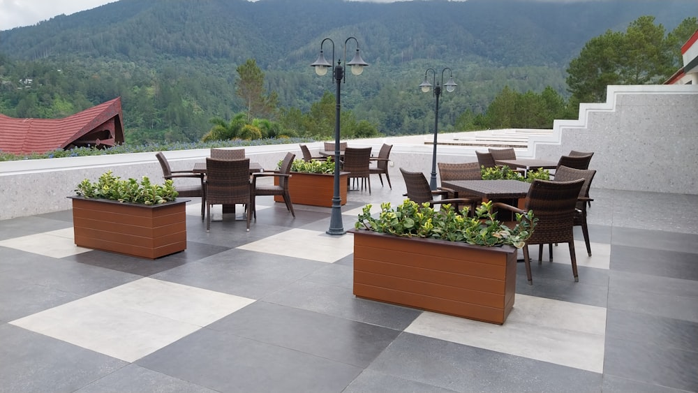 a patio with tables and chairs and a view of mountains