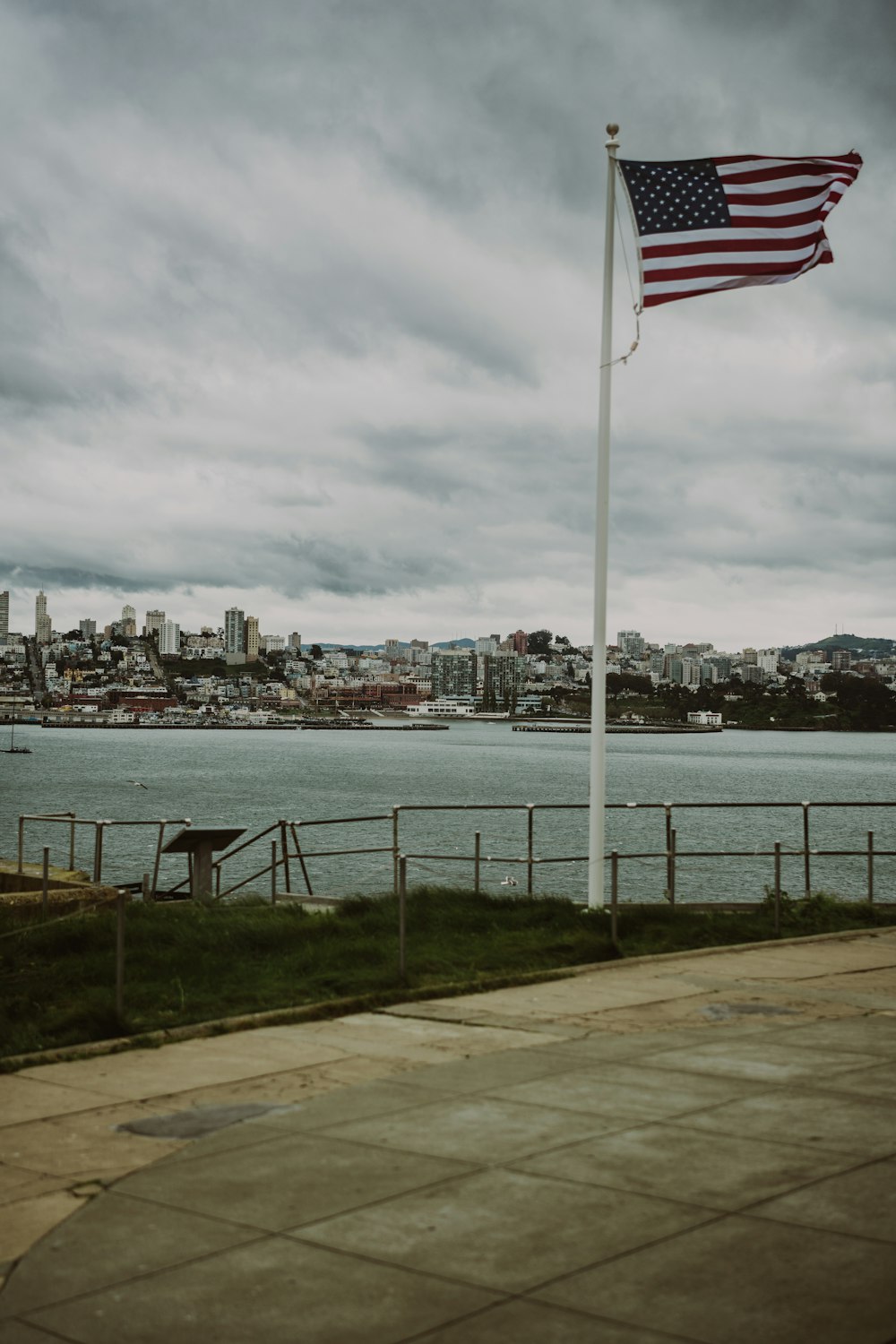 an american flag flying in front of a body of water