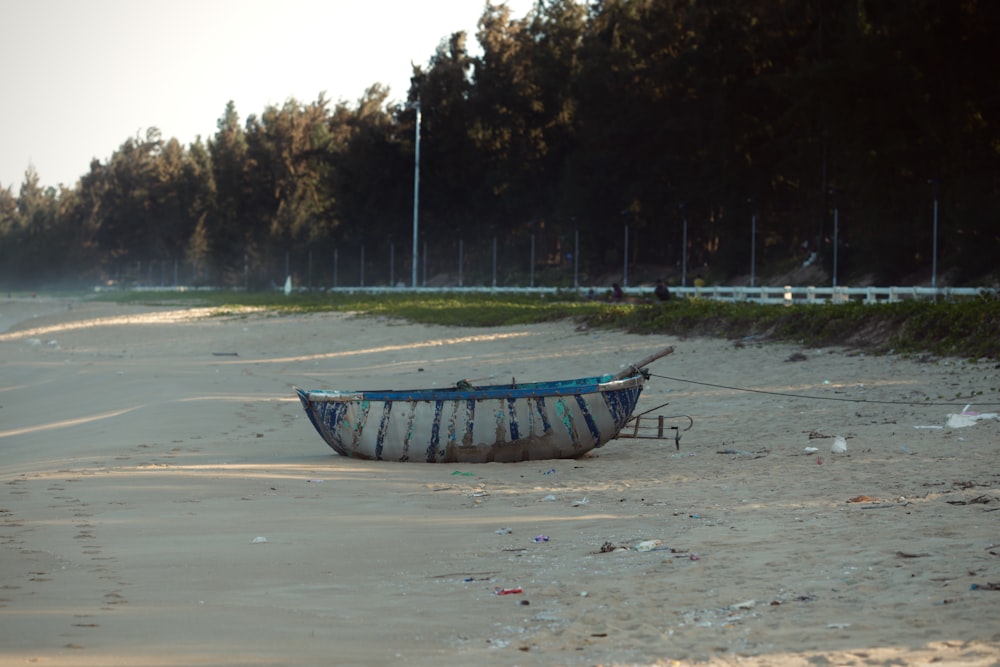 a boat sitting on top of a sandy beach