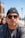 a man wearing sunglasses and a beanie looks at the camera