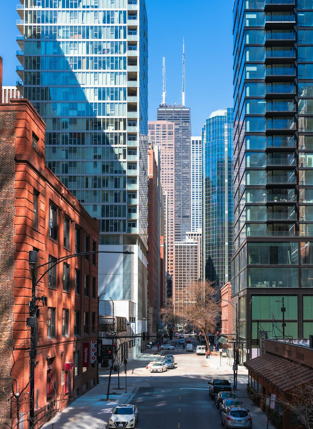 a city street lined with tall buildings and parked cars