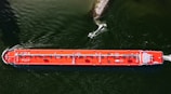 a large orange boat floating on top of a body of water