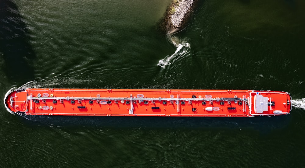 a large orange boat floating on top of a body of water