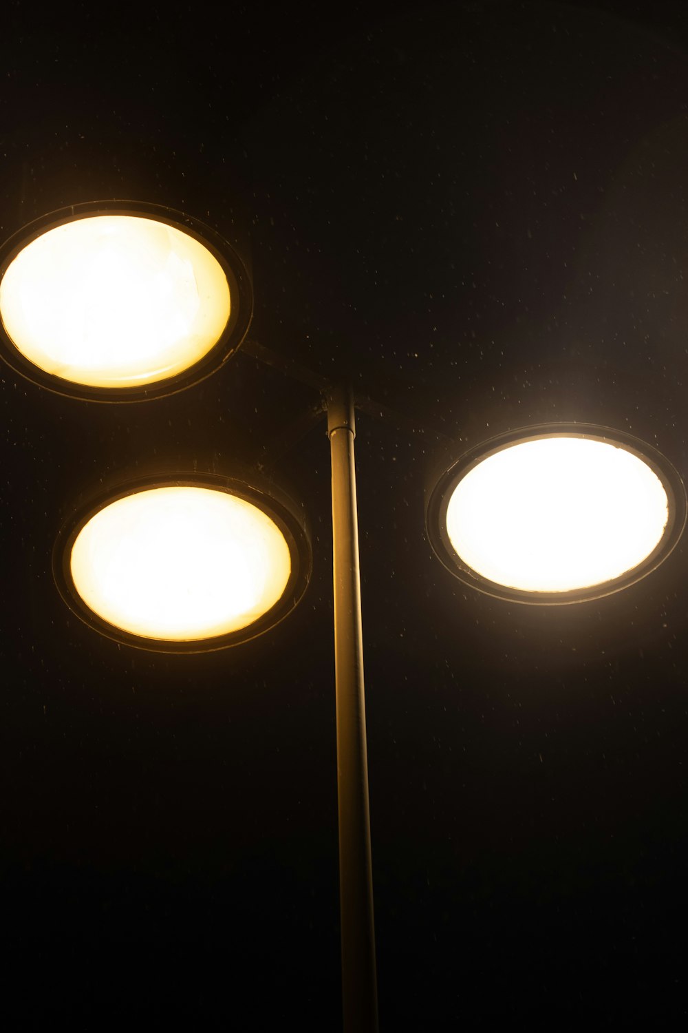 three street lights lit up in the dark