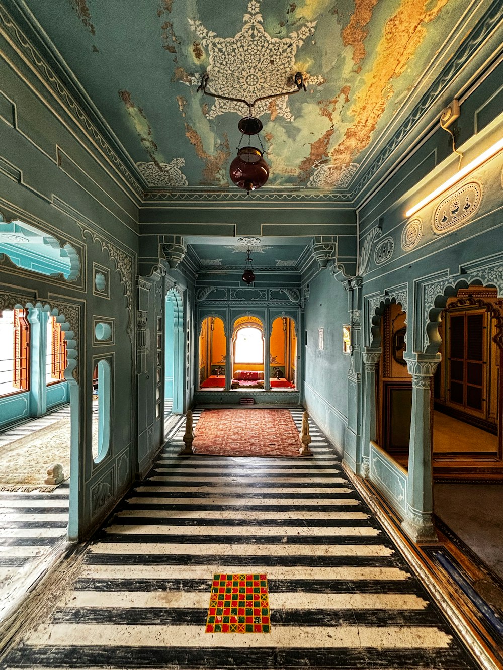 a room with a checkered floor and a painting on the ceiling