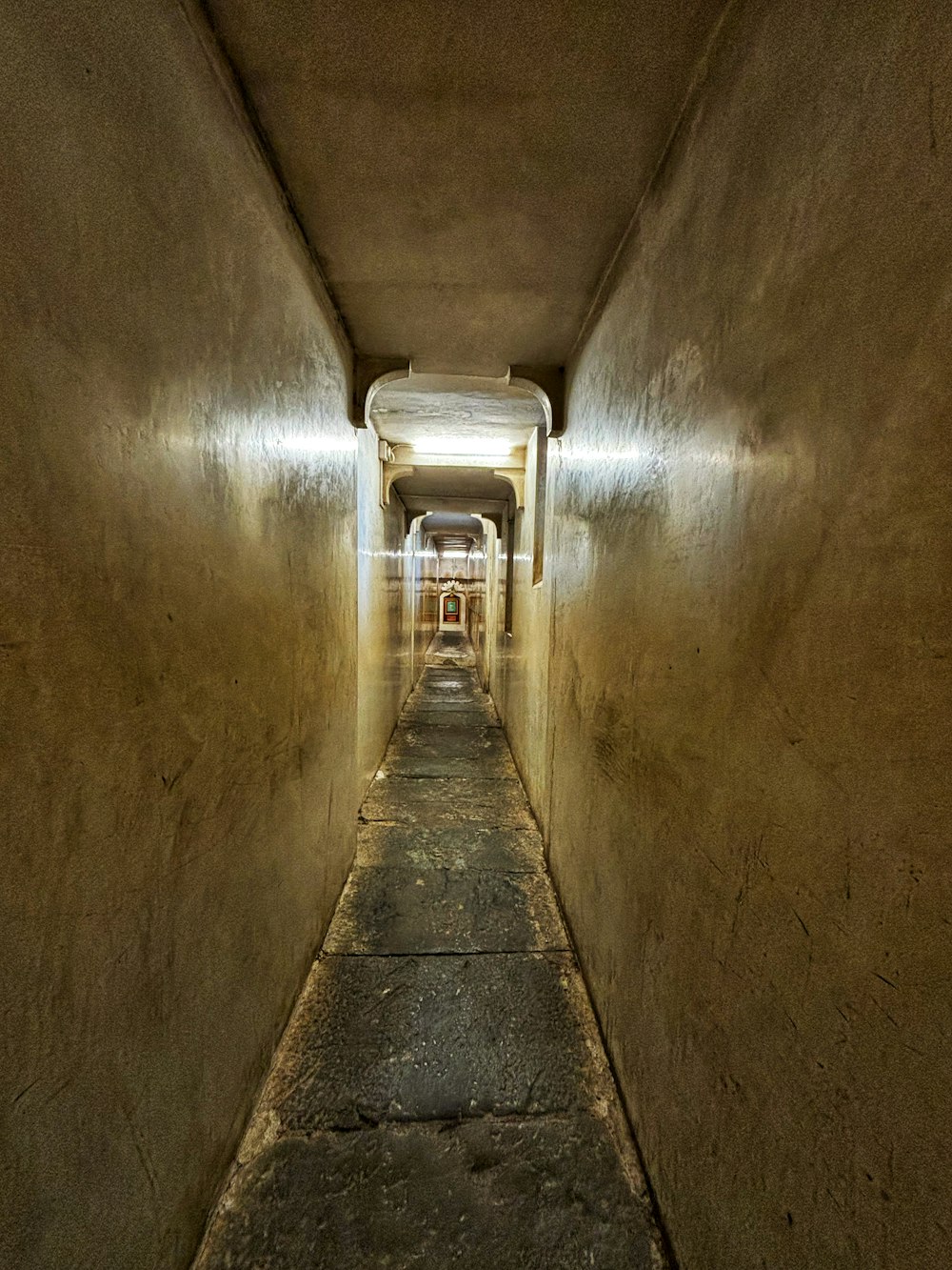 a long narrow hallway with a light at the end