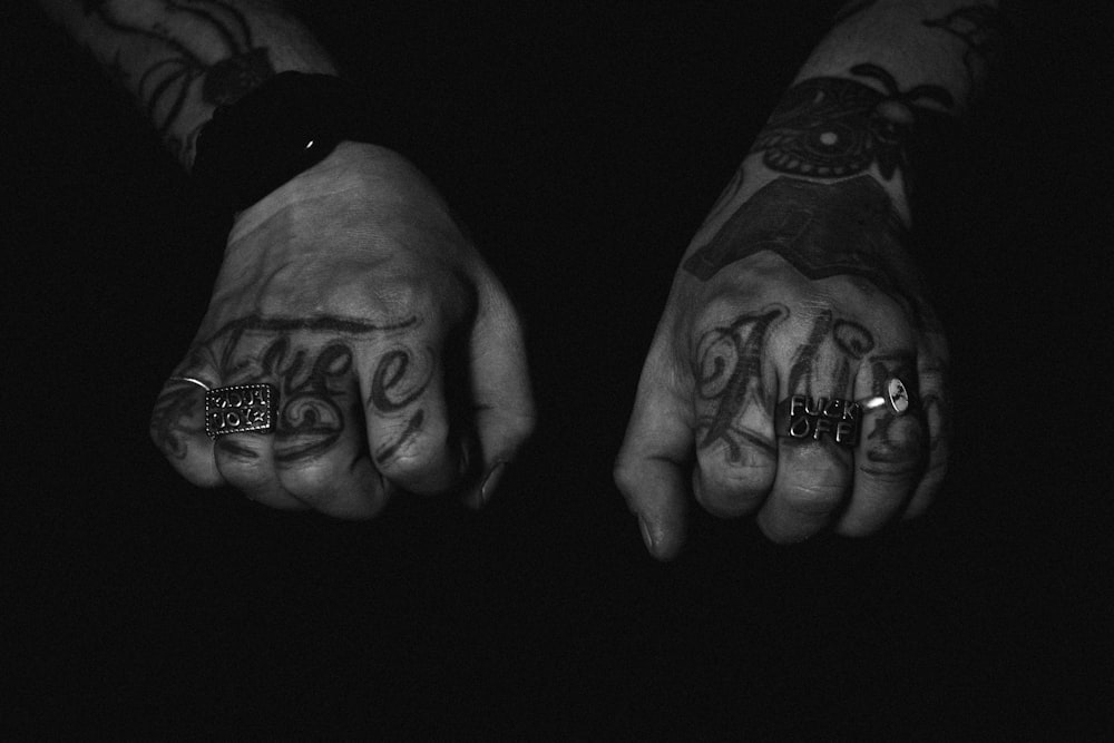 a pair of hands with tattoos on them