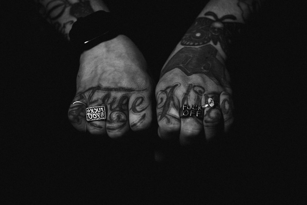 a person with two hands with tattoos on them