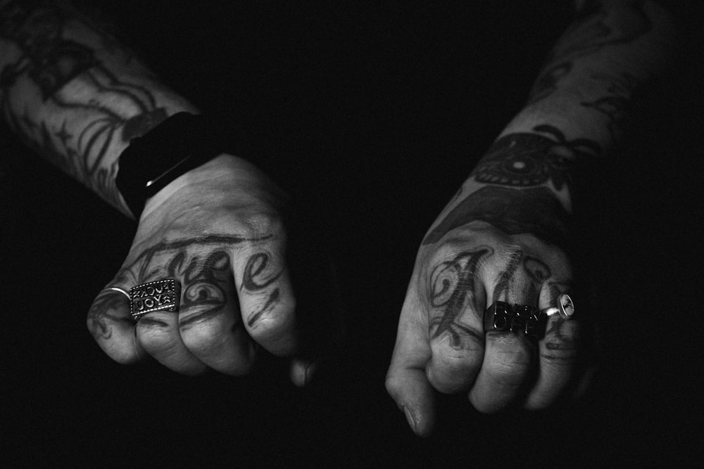 a person with tattoos on their hands holding something