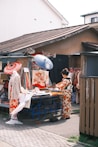 a group of people standing around a table with umbrellas