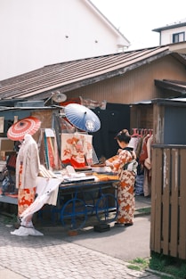 a group of people standing around a table with umbrellas
