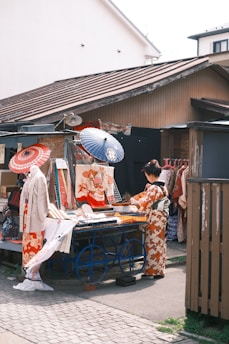 a group of people standing around a table with umbrellas