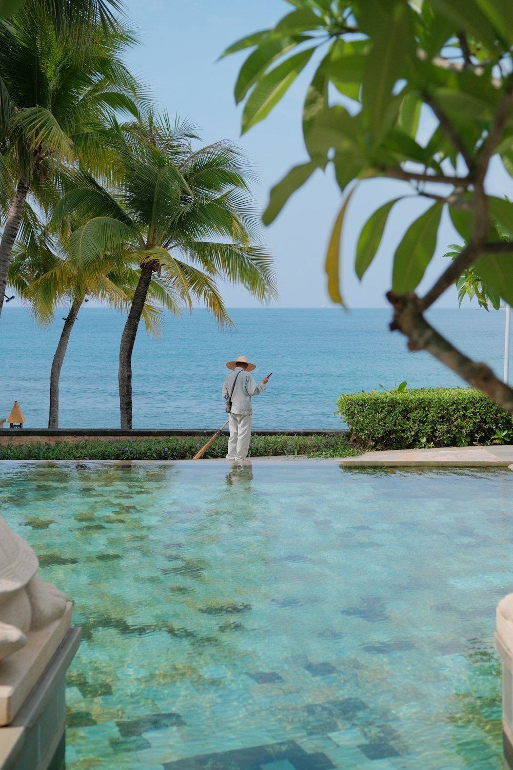 a man in a straw hat is standing in a pool