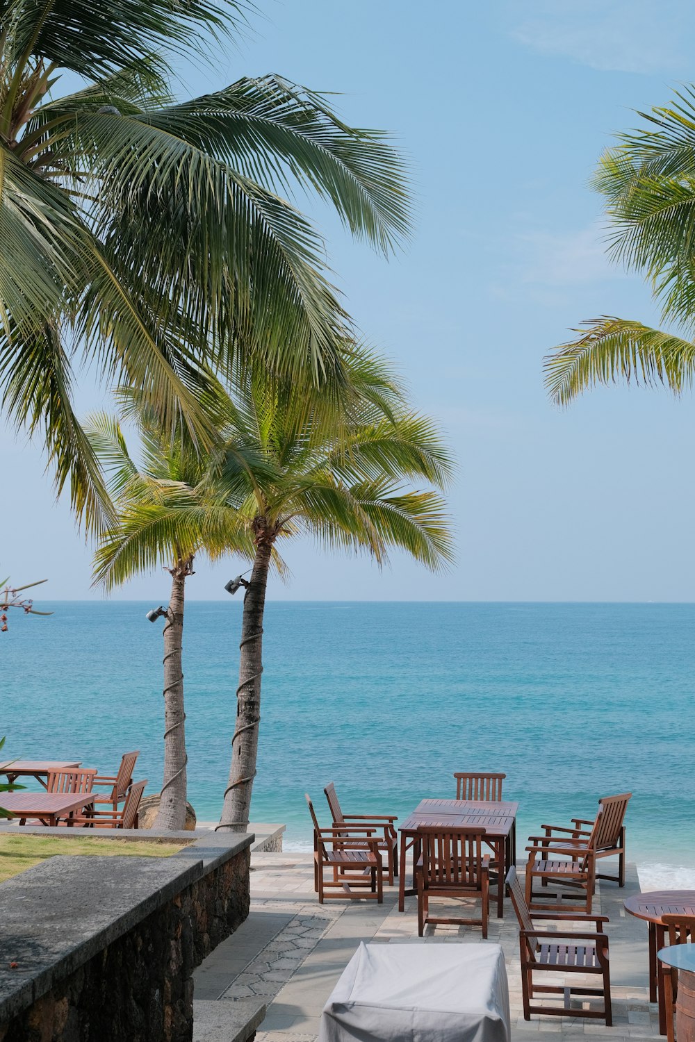 a table and chairs on a beach with a view of the ocean