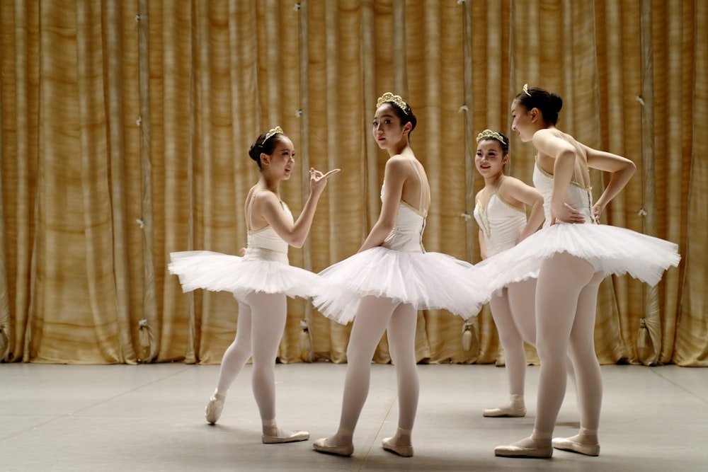 a group of ballerinas standing around each other
